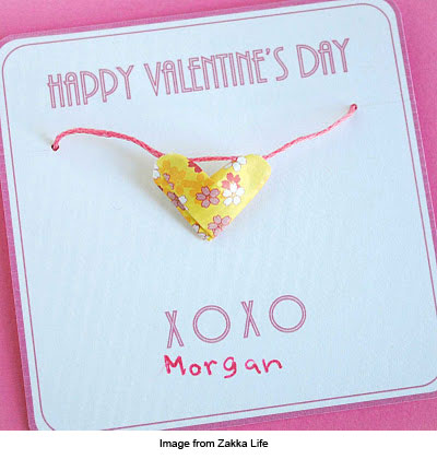 Necklace with paper origami heart pendant presented on a Valentine's day card.