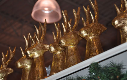 A line of golden deer peeking over the top shelf.